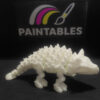 A white 3D printed flexi Ankylosaurus skeleton toy featuring a spiked armored back and a clubbed tail. The articulated model is shown in a standing profile view on a black surface.