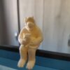 Alf figure holding a cat, sitting on a monitor.
