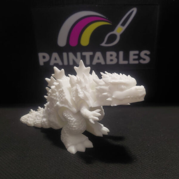 A white 3D printed Godzilla figure with textured skin and large dorsal fins. The articulated model is shown in a standing profile view, highlighting its reptilian scales, powerful legs, and jagged spine.