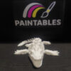 A head-on view of a white 3D printed Mosasaurus skeleton. The model features an elongated skull with a tapered snout, visible eye sockets, and four articulated flippers extended to the sides on a dark textured surface.