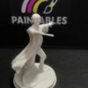 A white, unpainted 3D-printed miniature of Harry Potter in a dynamic spell-casting pose, standing on a circular base featuring a small broomstick and a golden snitch, set against a black "Paintables" background.